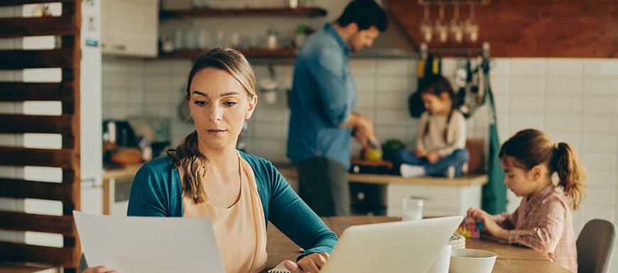 Family in kitchen with mom researching